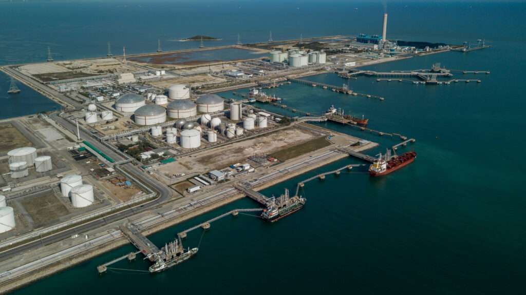 Aerial view oil tertminal storage tank, White oil tank storage chemical petroleum petrochemical refinery product at oil terminal, Business commercial trade fuel and energy transport by tanker ship vessel.
